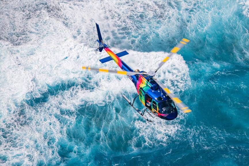 A Rainbow Helicopters Airbus A Star Flies Above The Waikiki Coastline